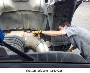 18-Wheeler Pre-trip Tire Inspection - A Professional Driver Is Under The Hood Of His Semi Truck Prior To Driving OTR.