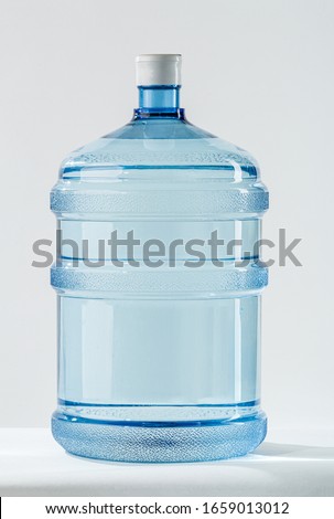 19 liter or 5 gallon refillable plastic water BPA Free jug dispenser. Concept of a mineral water delivery for homes and offices. Studio shot on white background. 