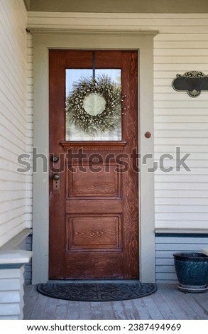 1910s narrow wood front door on a charming vintage cottage