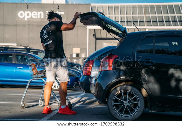 19/4/2020\
Oamaru, New Zealand. People unloading the stuff from supermarket to\
the car during the coronavirus\
pandemic.