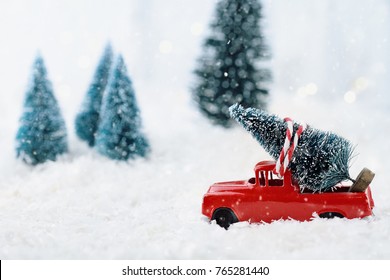 1950's antique vintage red truck hauling a Christmas tree home through a snowy winter wonder land. Extreme shallow depth of field with selective focus on vehicle. - Powered by Shutterstock