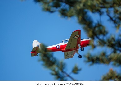 a 1951 De Havilland DHC-1 Chipmunk WD363 22 C-N C1-0304 flies low overhead in a deep blue autumn sky