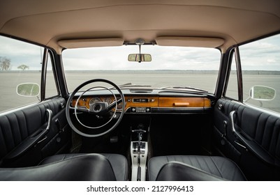 1960s car interior with black leather and wood trim. Symmetric image of classic style interior in restored condition. - Powered by Shutterstock