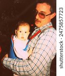 1980s dad and infant baby in carrier