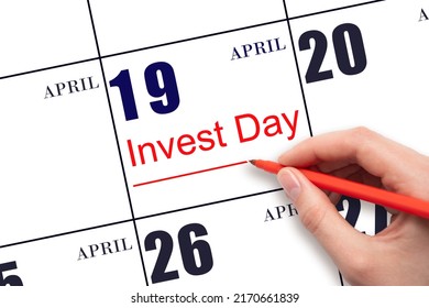 19th day of April.  Hand drawing red line and writing the text Invest Day on calendar date April 19.  Business and financial concept. Spring month, day of the year concept.