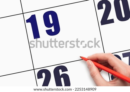 19th day of the month. Hand holding the red pen points to an empty calendar date. Design layout of an empty calendar date. A place for your text. Day of the year concept.