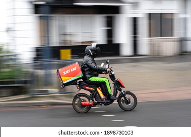 19th January 2021. London, UK. A Just Eat Delivery Guy Riding A Electric Motorbike With A Box. Blurred Background