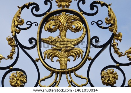 Nîmes, a 19th-century gate depicting the city's symbol: the chained crocodile and palm tree, based on a Roman coin minted in Nîmes 2,000 years ago to celebrate Augustus' conquest of Egypt. 