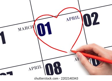 1st Day Of April.  A Woman's Hand Drawing A Red Heart Shape On The Calendar Date Of April 1. Heart As A Symbol Of Love. Spring Month. Day Of The Year Concept