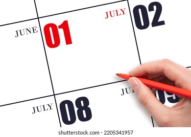 1st Day Of July. A Hand Holding A Red Pen And Pointing On The Calendar Date July 1. Red Calendar Date, Copy Space, Mockup. Summer Month, Day Of The Year Concept.