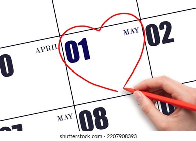 1st Day Of May. A Woman's Hand Drawing A Red Heart Shape On The Calendar Date Of 1 May. Heart As A Symbol Of Love. Spring Month. Day Of The Year Concept