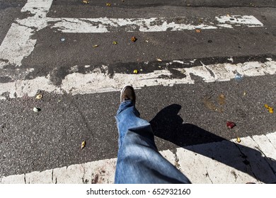 1st Person View Of The Photographer's Leg As He Is Crossing The Street.