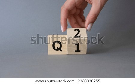 From 1st Quarter to 2nd symbol. Businessman hand Turnes cube and changes words 1st Quarter to 2nd Quarter. Beautiful grey background. Business and Quarter concept. Copy space