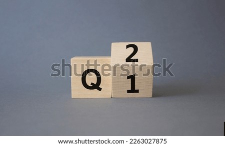 From 1st Quarter to 2nd symbol. Turned wooden cubes with words 1st Quarter and 2nd Quarter. Beautiful grey background. Business and Quarter concept. Copy space