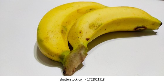 2 bananas arranged on a white surface Natural light and shadow Thailand