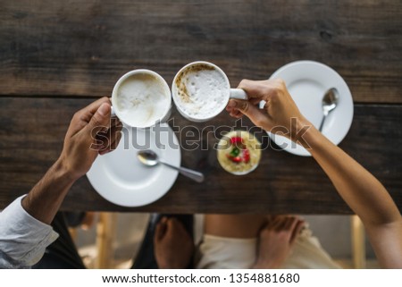 2 coffee cups in male and female hands top view