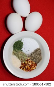 2 Eggs Placed On A Red Doily Next To A Bowl Of Different Spices
