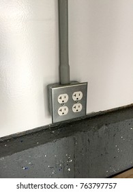 2 Gang Power Outlet Receptacle Box Mounted On A White Wall Over Concrete Flooring. Garage Workshop Type Setup. Electrical Romex Hot Neutral And Ground Copper Wire