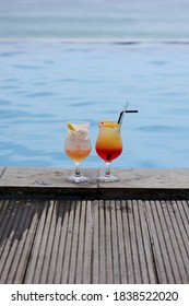 2 Glasses Of Cocktail By The Swimming Pool And The Sea With Bokeh Background. Holidays Destination Concept. Copy Space. No People.