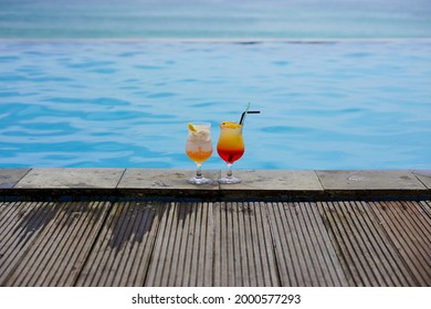 2 Glasses Of Cocktail By The Swimming Pool And The Sea With Bokeh Background. Holidays Destination Concept. Copy Space. No People.