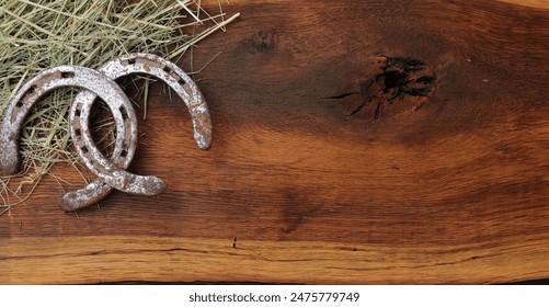 2 horseshoes with hay on a board as a background - Powered by Shutterstock