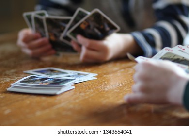 2 Kids Playing A Game Of Cards