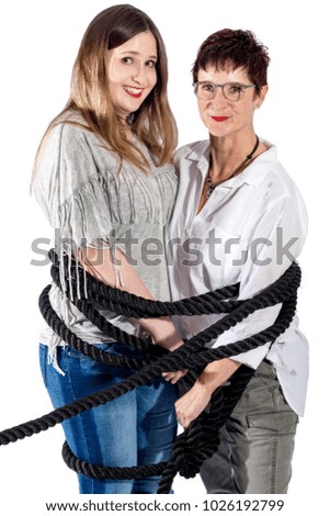 2 laughing women tied with a black rope