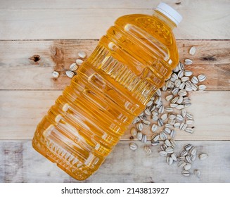 2 Litre Bottle Of Sunflower Oil For Cooking On Raw Wooden Surface With Sunflower Seeds