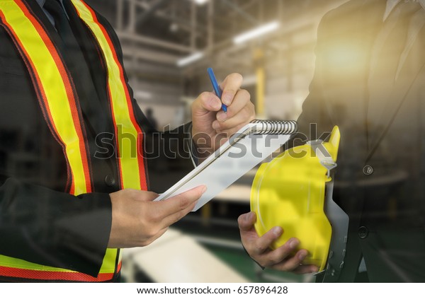 2 male occupational health and safety officer\
inside factory doing\
inspection