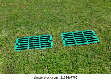 2 Manhole Drainage Grates On The Lawn With Green Grass Septic Tank Cover, Sump Cesspool Drainage System Environment Design, Close Up View Lit By Sun On Dry Weather, Nobody.