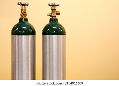 2 Medical Oxygen Tanks On Yellow Background