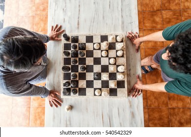 2 Men Are Playing A Chess Game