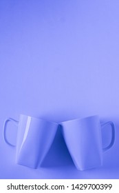 2 Monochromatic Blue Coffee Mugs On Blue Background Clinking In Cheers With Blank Empty Room Space For Text, Copy, Or Copyspace. Modern Top View Concept Of Two Cups With Solid Background Backdrop.