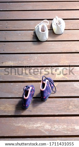 2 pairs ok kid shoes on the vintage wood surface.