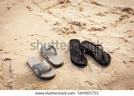 2 pairs of slippers by the beach
