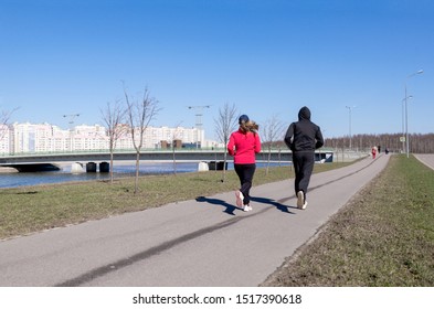 2 people running down the street in the city along the river embankment on the background of buildings, runners - Shutterstock ID 1517390618