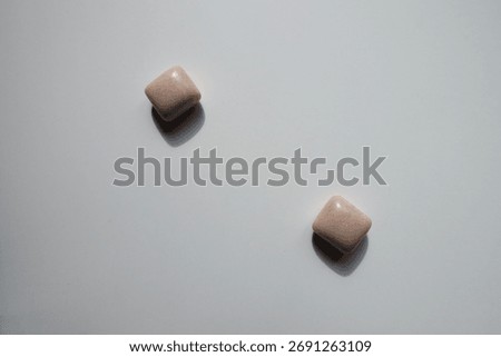 2 pink rectangular pieces of chewing gum from above