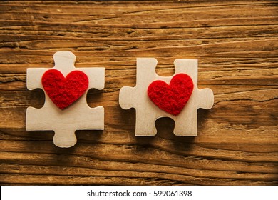 2 puzzle.Two red hearts on wooden part on table texture background. idea, sign, symbol, concept of true romantic passion, couple in love, sex. happy valentine's day