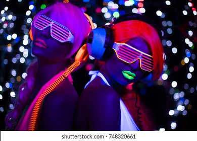2 sexy cyber glow raver women filmed in fluorescent clothing under UV black light