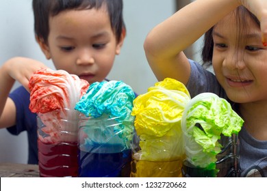 2 Sibling Asian Kids Making Simple Science Experiment At Home.2 Years And 6 Years Old Kid Make How Plants Absorb Water And Nutrients Up Through Their Stems By Using  Cabbage Leaves And Food Coloring.