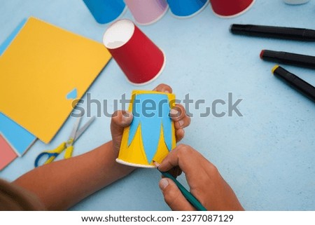 2 - Step by step diy process. Kids craft multicoloured fish from a paper coffee cup, zero waste concept.