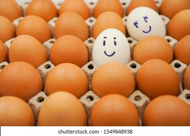 2 White Eggs Among Many Brown Eggs In The Egg Carton With Smile And Happy Face ,  Secretly Love Or Secret Crush On Somebody And Valentines Concept ,selective Focus