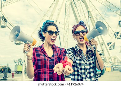 2 women shouting with megaphones - female activists march at a student strike protest rally - workers day or political demonstration - concept of rebel women in street protests for rights activism  - Shutterstock ID 411926074