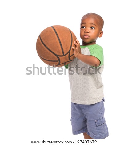 2 year old African American baby boy standing holding basket ball on isolated background