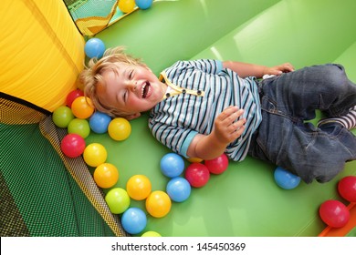 2 year old boy smiling on an inflatable bouncy castle - Shutterstock ID 145450369