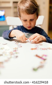 2 Year Old Child Concentrating And  Solving Jigsaw Puzzle