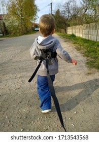 2 Year Old Toddler Baby Boy Tethered On A Leash. Child Wearing Harness Runs On The Path