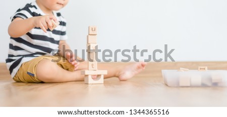 2 years baby boy.Little child boy playing with lots of wooden toys block with mother.Kids play with educational toys at home.Day care and Kindergarten school.child development concept. 