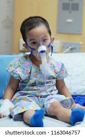 2 Years Old Asian Toddler Boy Has Asthma Or Pneumonia Disease And Need Nebulizations,Sick Boy Rest On Patien Bed And Has Inhalation Therapy By The Mask Of Inhaler.Sick Or Cancer Child Awareness.