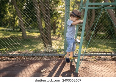 2 years old boy climbing ladder with hat in park. - Powered by Shutterstock